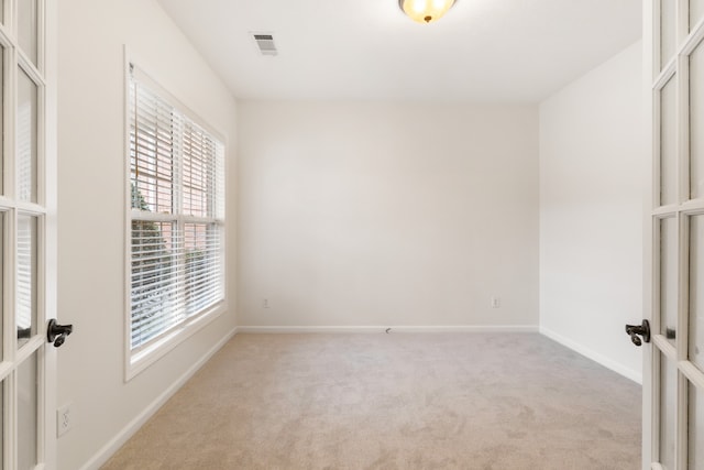 carpeted empty room featuring french doors