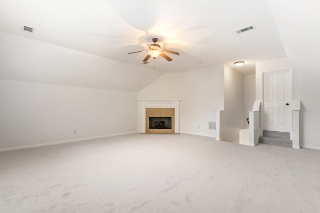 unfurnished living room featuring a fireplace, light colored carpet, vaulted ceiling, and ceiling fan