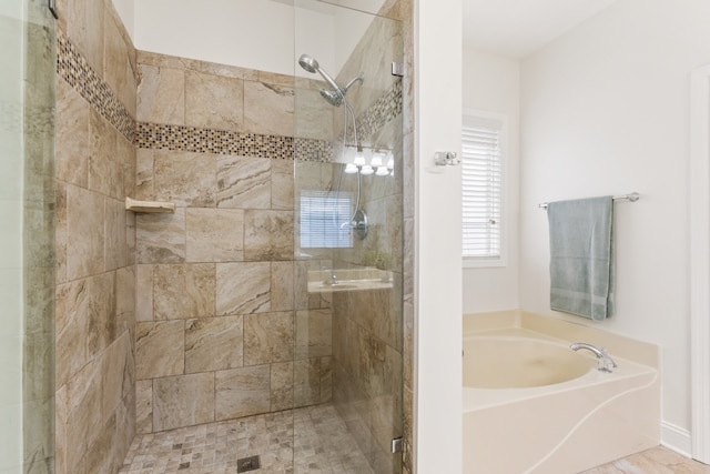 bathroom featuring shower with separate bathtub