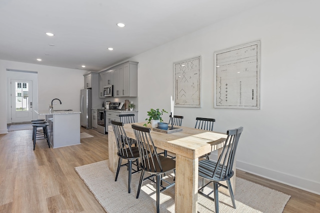 dining space featuring sink and light hardwood / wood-style flooring