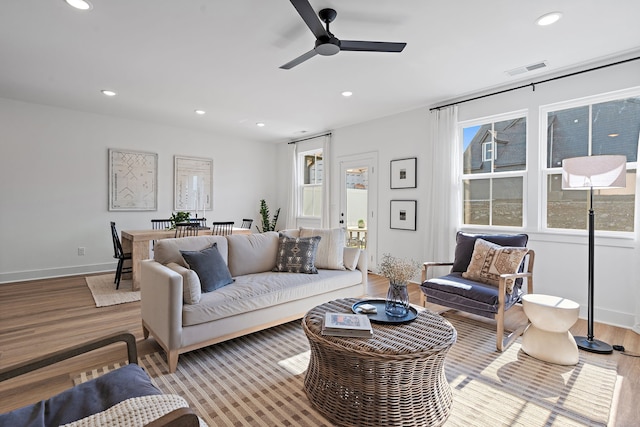 living room with ceiling fan and light hardwood / wood-style flooring