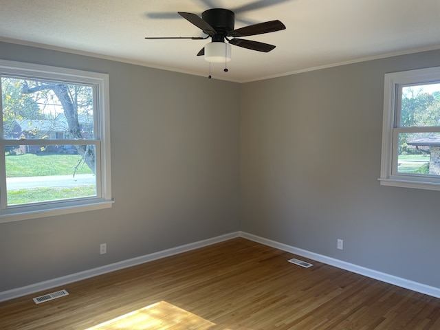 spare room with crown molding, wood-type flooring, and ceiling fan