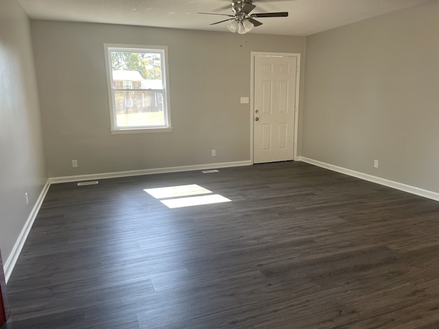 unfurnished room with dark hardwood / wood-style floors and ceiling fan