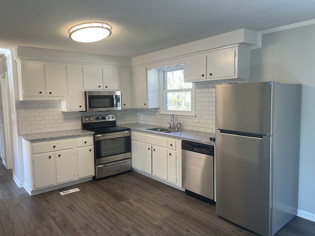 kitchen with white cabinets, stainless steel appliances, and dark hardwood / wood-style flooring