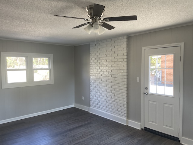 foyer with crown molding, dark hardwood / wood-style floors, and a textured ceiling