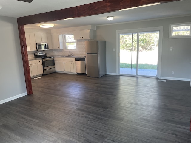 kitchen with appliances with stainless steel finishes, decorative backsplash, white cabinets, and dark hardwood / wood-style flooring