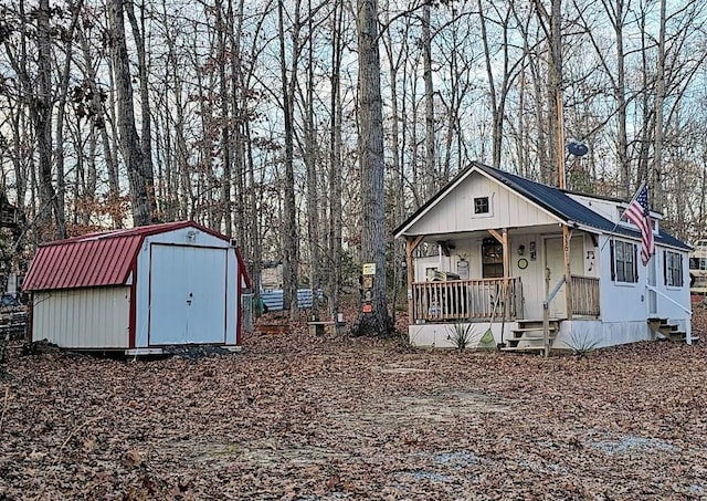 view of front of home featuring a porch and a storage shed