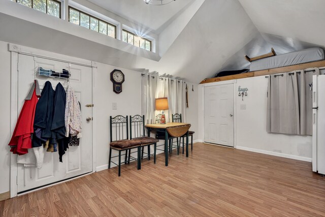 entrance foyer featuring vaulted ceiling and light hardwood / wood-style flooring