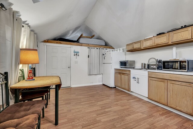 kitchen with light brown cabinets, sink, white refrigerator, light hardwood / wood-style floors, and vaulted ceiling