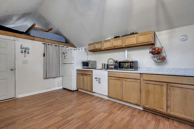 kitchen with light wood-type flooring, white fridge, lofted ceiling, and sink