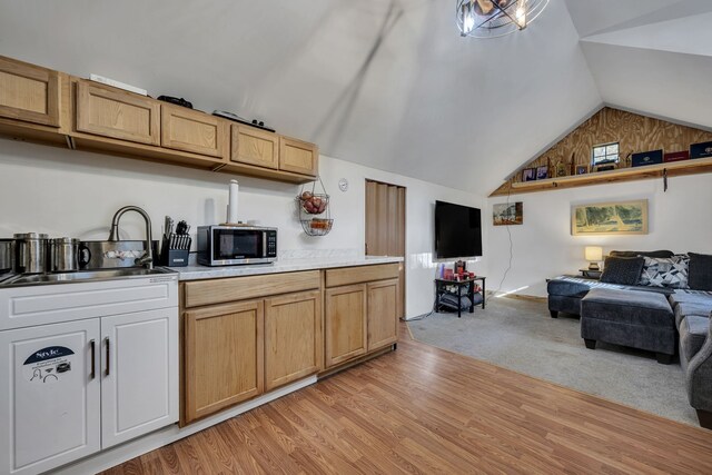 kitchen featuring light carpet, an inviting chandelier, and vaulted ceiling