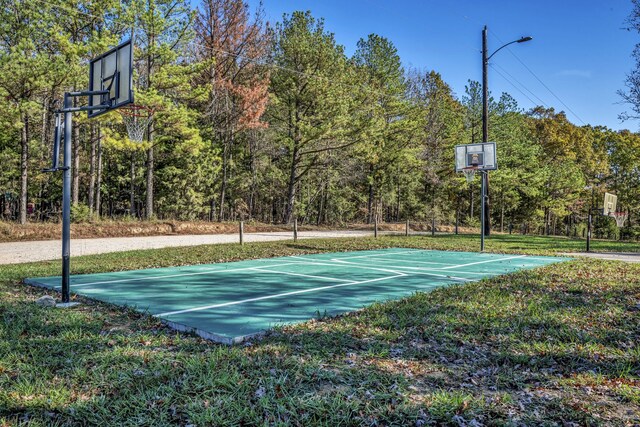 view of sport court with a yard