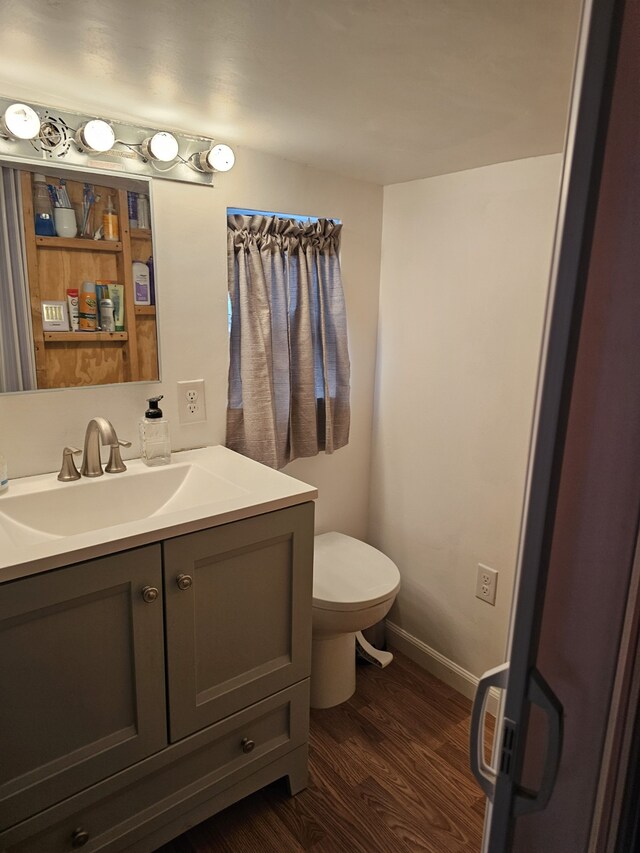 bathroom featuring vanity, toilet, and wood-type flooring