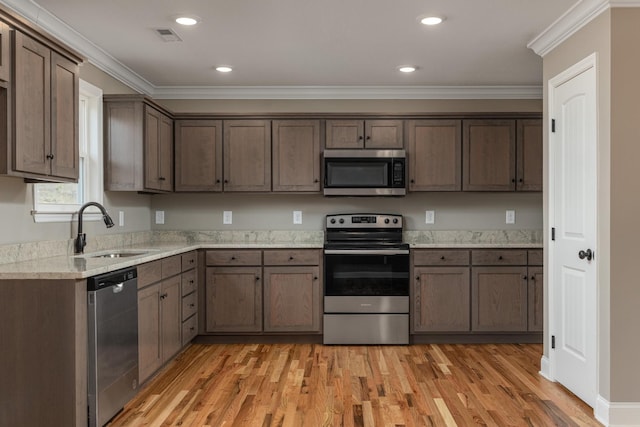 kitchen featuring crown molding, sink, stainless steel appliances, and light wood-type flooring