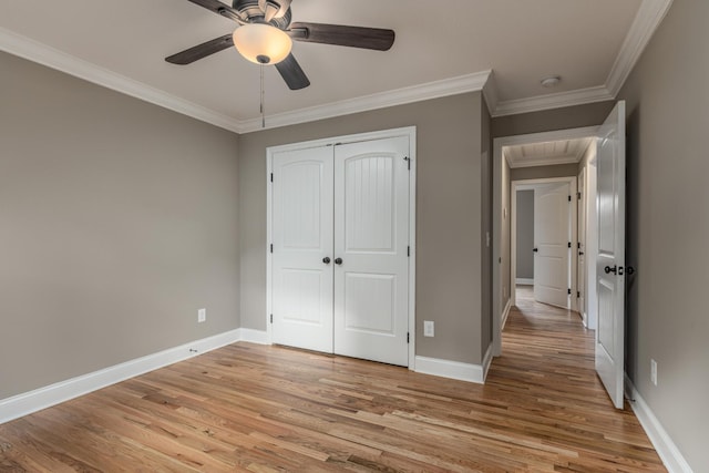 unfurnished bedroom with light wood-type flooring, a closet, ceiling fan, and ornamental molding