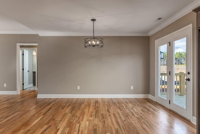 unfurnished room with a chandelier, crown molding, and light hardwood / wood-style floors