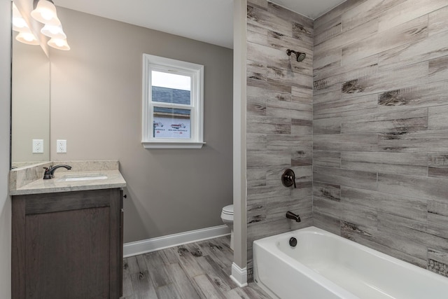 full bathroom with hardwood / wood-style floors, vanity, toilet, and tiled shower / bath