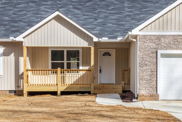 view of exterior entry featuring a garage and covered porch