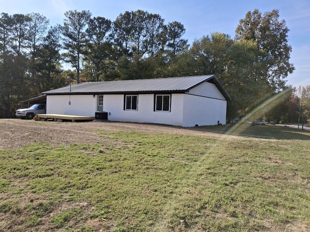 view of front facade with central AC unit, a front yard, and a carport