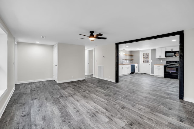 unfurnished living room with light hardwood / wood-style floors, ceiling fan, and sink