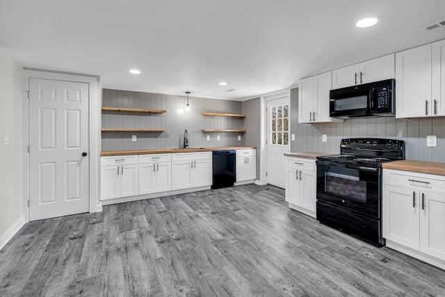 kitchen with black appliances, backsplash, wood counters, white cabinetry, and light hardwood / wood-style flooring