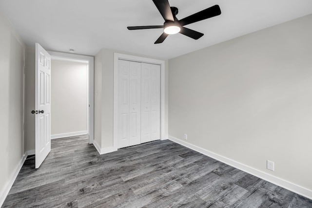 unfurnished bedroom featuring ceiling fan, a closet, and wood-type flooring