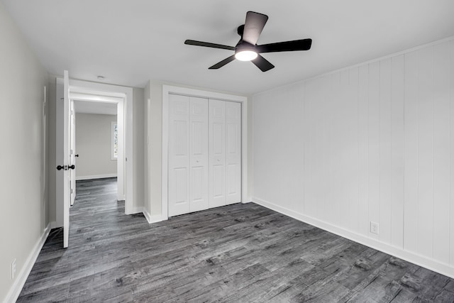 unfurnished bedroom with dark hardwood / wood-style flooring, ceiling fan, and a closet