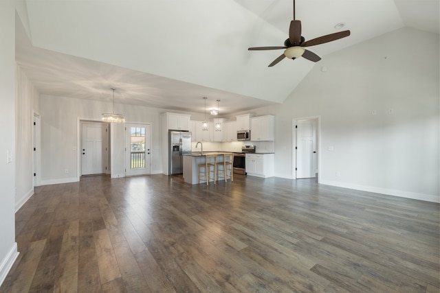 unfurnished living room featuring high vaulted ceiling, sink, dark hardwood / wood-style floors, and ceiling fan with notable chandelier