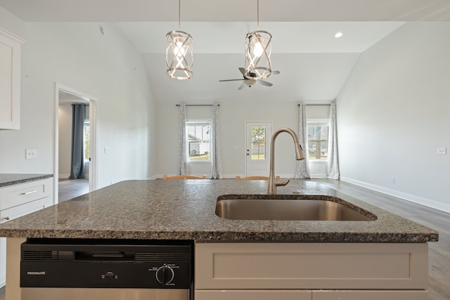 kitchen with lofted ceiling, white cabinets, sink, and a center island with sink