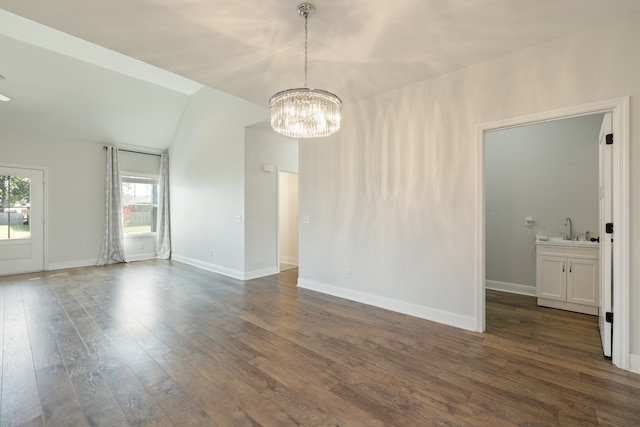 empty room featuring sink, vaulted ceiling, dark hardwood / wood-style floors, and an inviting chandelier