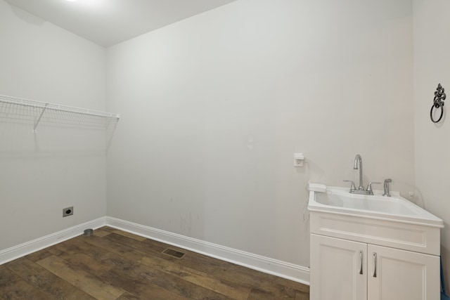 laundry area featuring dark wood-type flooring, hookup for an electric dryer, and sink