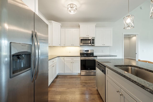 kitchen featuring white cabinetry, stainless steel appliances, dark stone counters, and dark hardwood / wood-style floors