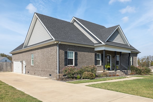 craftsman-style house featuring covered porch, a garage, and a front lawn