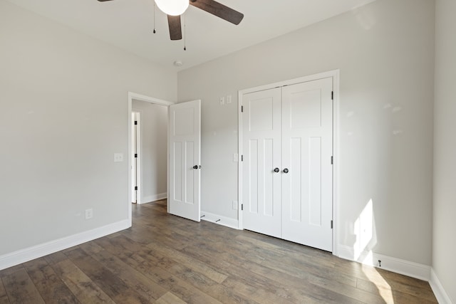 unfurnished bedroom featuring dark wood-type flooring, a closet, and ceiling fan