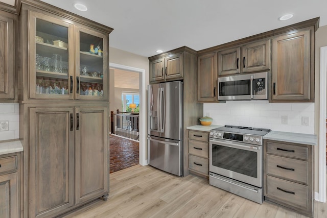 kitchen featuring tasteful backsplash, appliances with stainless steel finishes, and light hardwood / wood-style floors