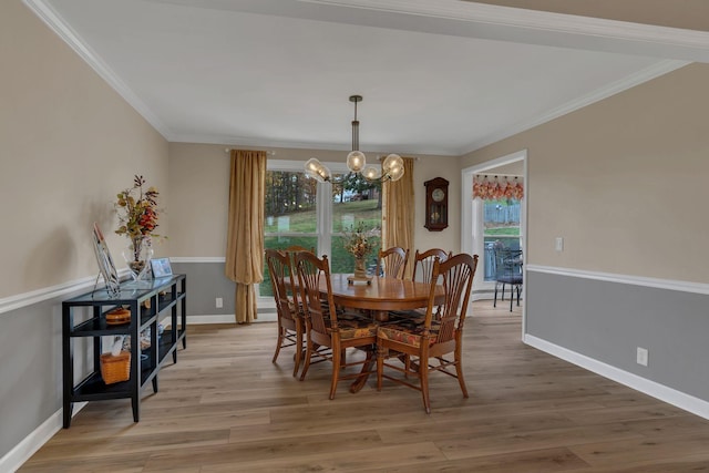 dining space with crown molding, wood-type flooring, and a chandelier