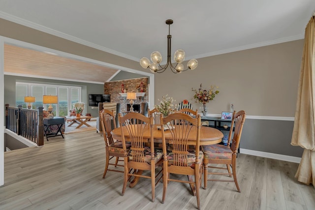 dining space with an inviting chandelier, crown molding, and light hardwood / wood-style flooring