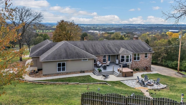 rear view of property with a wooden deck, a yard, a patio area, and an outdoor living space with a fire pit