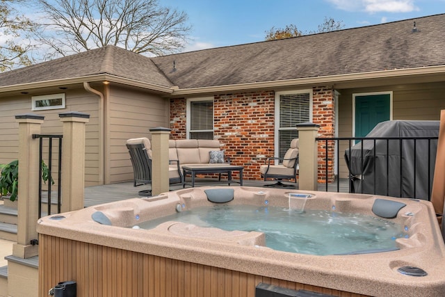 wooden terrace featuring a hot tub