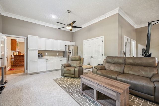 carpeted living room featuring ornamental molding, a textured ceiling, ceiling fan, and a high ceiling