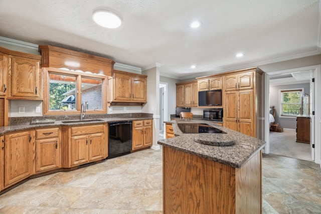 kitchen featuring a center island, black appliances, sink, crown molding, and dark stone countertops