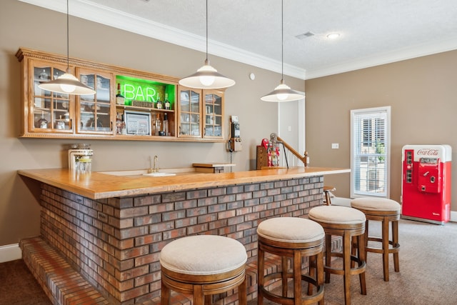 bar with ornamental molding, carpet, a textured ceiling, and decorative light fixtures