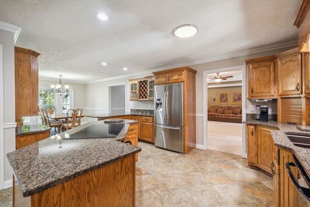 kitchen featuring appliances with stainless steel finishes, a textured ceiling, crown molding, and a center island