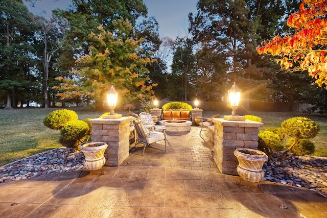 patio terrace at dusk featuring a lawn