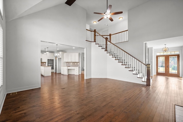 unfurnished living room with french doors, ceiling fan, high vaulted ceiling, and dark hardwood / wood-style flooring