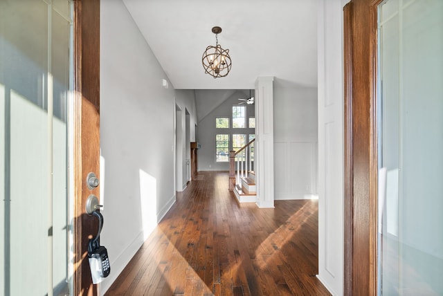 hallway featuring vaulted ceiling, a notable chandelier, and dark hardwood / wood-style flooring