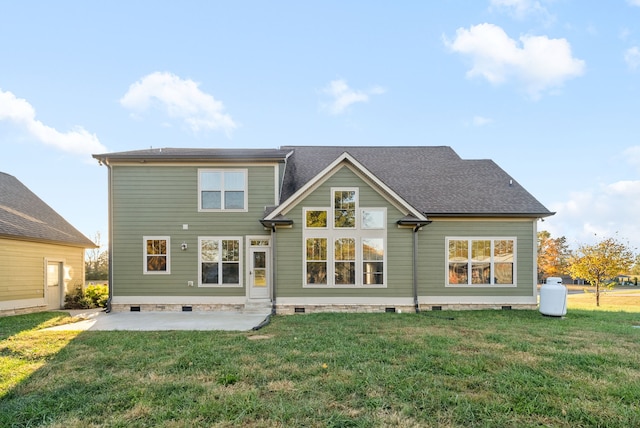 back of property with a yard and a patio area