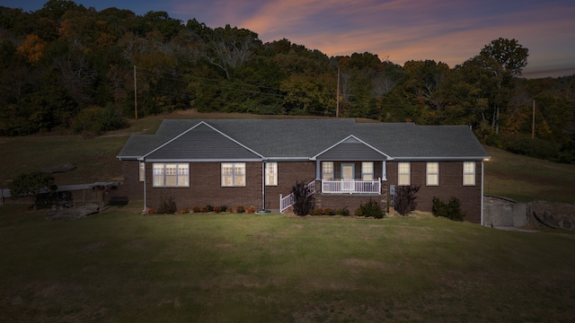 ranch-style house with a yard and covered porch