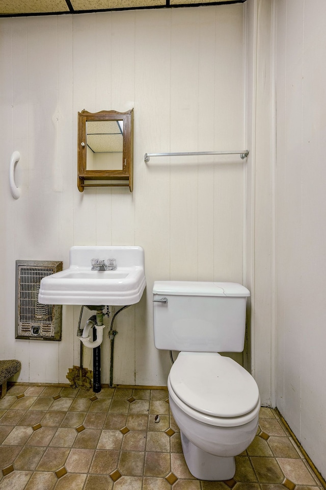 bathroom with heating unit and toilet