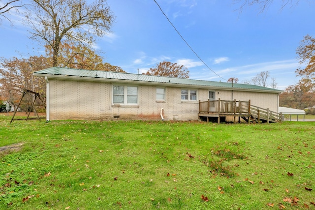 back of house with a deck and a yard